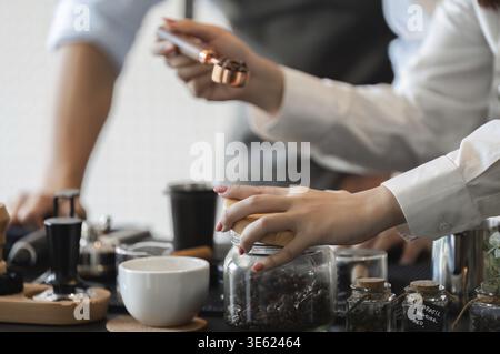 Ein Barista konzentriert sich auf die Präzision der Kaffeezubereitung und zeigt die Kunst der Kaffeezubereitung mit spezialisierten Werkzeugen in einem einladenden Café Stockfoto