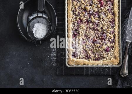 Essen, Kirsch- und Mandel-Streuseltorte, schwarzer Hintergrund, Blick von oben Stockfoto