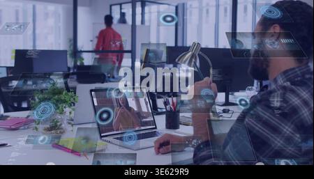 Hält Lampe, bärtiger Mann in kariertem Hemd und beobachtet Laptop im Büro mit UI-Overlays, Kopierraum Stockfoto