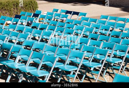 Reihen blauer Klappstühle, die für eine Veranstaltung im Freien in der Marina di Venezia in Italien angeordnet sind und eine organisierte Sitzordnung im Freien zeigen. Stockfoto