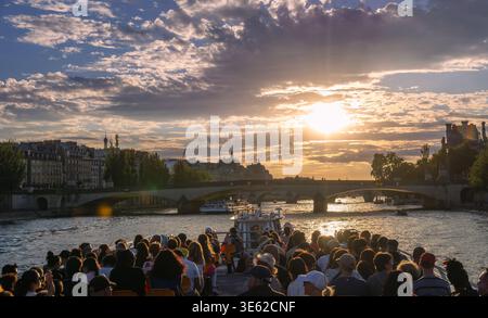 Paris, Frankreich - 08 04 2025: Ein Weitwinkelblick von der Rückseite eines überfüllten Bootes auf der seine. Touristen werden dabei beobachtet, wie sie Fotos machen und die Sonnen genießen Stockfoto