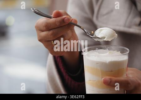 Genießen Sie ein Dessert mit Löffel in der Hand in einem Café Stockfoto