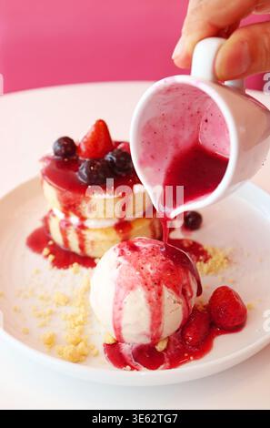 Vanilleeis und Chiffonkuchen mit köstlicher gemischter Beerensauce Stockfoto