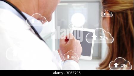 Tablette halten, Dr. in weißem Mantel, der Wolkenstatistiken für ältere Frau im Stethoskop des Krankenhausflugs zeigt Stockfoto