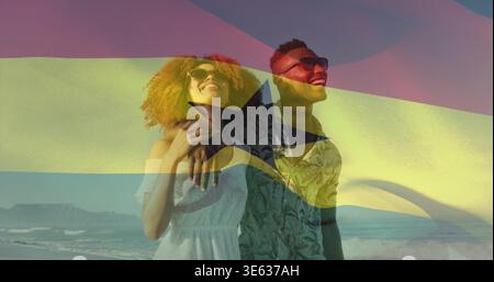 Stehendes Paar, das sich an der Küste umgibt, trägt weiße Sonnenbrillen gemustertes Hemd Ghana Flag Overlay Stockfoto