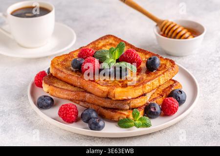 Französischer Toast mit Heidelbeeren, Himbeeren, Ahornsirup, Frühstück am Morgen. Stockfoto