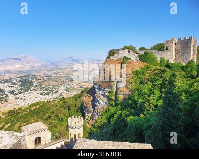 Eine mittelalterliche Steinburg und Festung auf einer steilen Felsklippe, bedeckt von üppiger grüner Vegetation, mit Blick auf eine weite Panoramablick Stockfoto