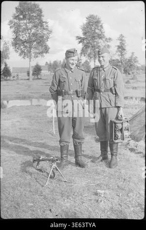 Zwei Wehrmachtssoldaten mit MG 34 Maschinengewehr und Munitionsträger, Foto II. Weltkrieg. Stockfoto