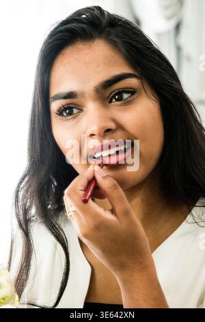 Eine junge Erwachsene, Teenagerin aus Hindustani, die sich am Samstag in ihrem Wohnzimmer schminkt. Rotterdam, Niederlande. MR=JA Stockfoto