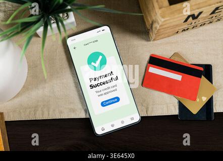 Smartphone mit Benachrichtigung über erfolgreiche Zahlung auf dem Bildschirm. Mobiles Banking und Online-Transaktionskonzept mit Kreditkarten- und Digital Finance-Technologie Stockfoto