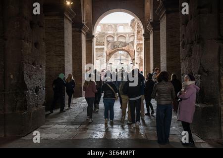ROM, ITALIEN - 27. März 2026: Eine Menge Touristen spaziert durch die alten gewölbten Korridore des Kolosseums, mit Blick durch einen Bogengang in Richtung t Stockfoto