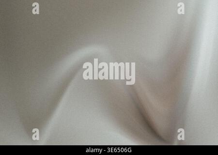 Dieses Bild zeigt eine Nahansicht eines glatten grauen Stoffes mit subtilen Falten und Falten, die seine Textur und sanfte Kurven hervorheben. Die Fabric-App Stockfoto