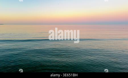 Tiefblaues Meer unter einem verlaufenden Sonnenuntergang Himmel. Friedliche abendliche Ozeanoberfläche. Stockfoto
