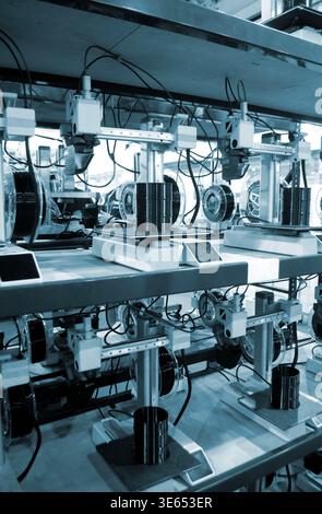 Viele 3D-Drucker drucken Objekte. 3D-Drucker, die eine Form aus geschmolzenem Kunststoff erzeugen, der aus dem Extruder fließt. Nahaufnahme des 3D-Druckers. Arbeitender 3D-Drucker druckt Objekt aus geschmolzenem schwarzem Kunststoff Stockfoto