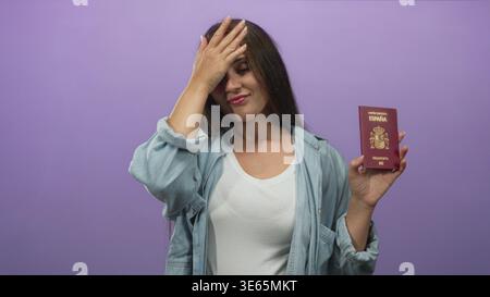Frau mit spanischem Pass und Hand auf die Stirn im Studio mit violettem Hintergrund; peinlich. Stockfoto