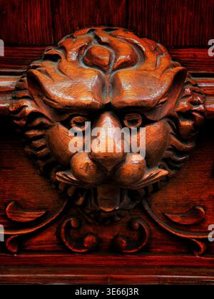 Detail einer kunstvollen Holztür mit handgeschnitzter Löwenkopf-Skulptur als dekorativen Akzent Stockfoto