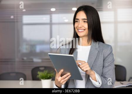 Porträt einer nachdenklichen Geschäftsfrau, die im Sitzungssaal an einem digitalen Tablet arbeitet Stockfoto