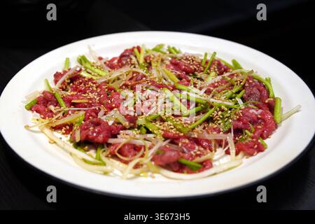 Koreanischer Rindertatar, Yukhoe, gewürzt mit Sesamöl und Kräutern Stockfoto