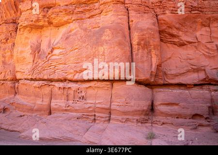 Die geschichtete rote Sandsteinwand entlang der Shafer Canyon Road, Utah, zeigt Erosionsmuster und natürliche Wüstenfelsen. Stockfoto