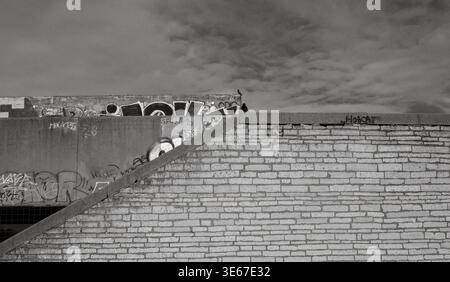 Graffiti-bedeckte Ziegelmauer und Metalltreppe am verlassenen Rathaus in Tallinn, Estland, März 2026 Stockfoto