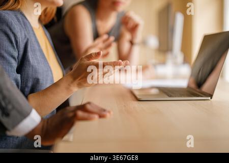 Mittelteil der Geschäftsfrau, die während des Meetings Projektdetails über einen Laptop erläutert Stockfoto