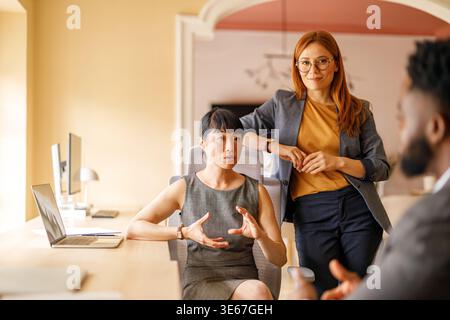 Team aus verschiedenen Geschäftsleuten, die Ideen während eines produktiven Meetings am Arbeitsplatz Brainstorming und Diskussion Stockfoto