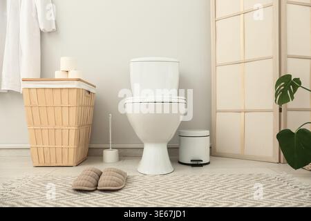 Das Innere des stilvollen Toiletten mit Keramikschale, Mülleimer und Korb Stockfoto