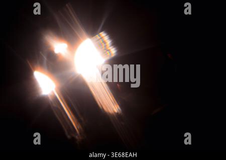 Sonne, Sonnenstrahlen, Sonnenstrahlen, Sonnenschein-Design. Gelber warmer Lichteffekt, Sonnenstrahlen, goldene Strahlen isoliert auf schwarzem Hintergrund. Stern-Do. Beleuchtung der Autoscheinwerfer Stockfoto