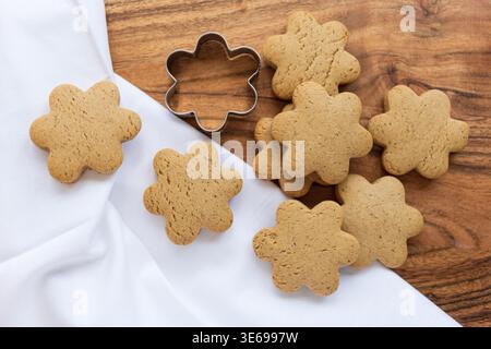 Nahaufnahme goldener hausgemachter Kekse auf Holzoberfläche. Warme Töne und Tageslicht sorgen für eine gemütliche Backatmosphäre. Stockfoto