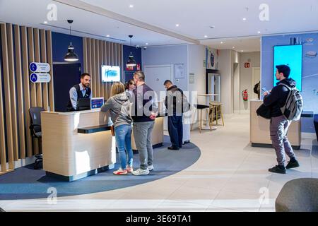 Madrid Spanien, Holiday Inn Express IHG Hotel, Inneneinrichtung, Hotelrezeptionspersonal, Gäste Männer Frauen Erwachsene, die in der Warteschlange einchecken, Hotel Stockfoto
