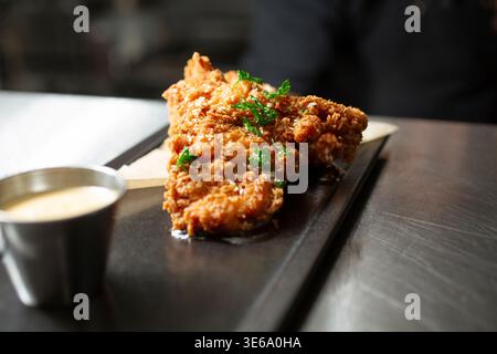 Ein Blick auf eine Bestellung von gebratenem Huhn in einem Restaurant geht durch das Fenster. Stockfoto