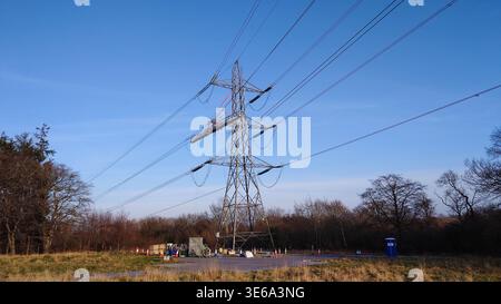 igh-Spannungs-Übertragungsturm mit abgehängter Wartungsplattform und Instandhaltungsarbeiten unter dem Turm Stockfoto
