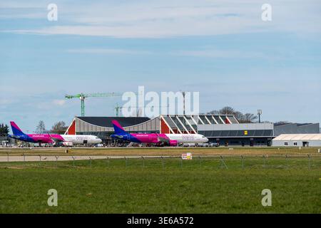 Memmingerberg, Bayern, Deutschland - 5. April 2026: Zwei Wizz Air Passagierflugzeuge warten auf den Check-in am Flughafen Allgäu Memmingen. Im Hintergrund sind Krane und Bauarbeiten zum Ausbau der Flughafeninfrastruktur sichtbar *** zwei Passagierflugzeuge der Wizz Air stehen zur Abfertigung am Terminal des Allgäu Airport Memmingen. Im Hintergrund sind Kräne und Bauarbeiten zur Erweiterung der Flughafen-Infrastruktur sichtbar Stockfoto