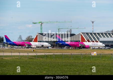 Memmingerberg, Bayern, Deutschland - 5. April 2026: Zwei Wizz Air Passagierflugzeuge warten auf den Check-in am Flughafen Allgäu Memmingen. Im Hintergrund sind Krane und Bauarbeiten zum Ausbau der Flughafeninfrastruktur sichtbar *** zwei Passagierflugzeuge der Wizz Air stehen zur Abfertigung am Terminal des Allgäu Airport Memmingen. Im Hintergrund sind Kräne und Bauarbeiten zur Erweiterung der Flughafen-Infrastruktur sichtbar Stockfoto