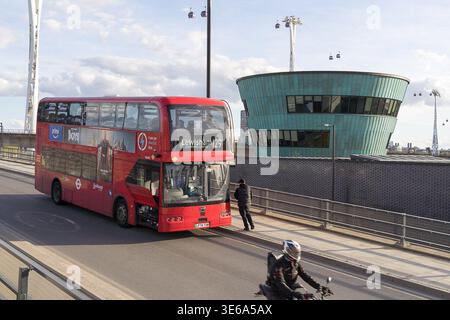 LONDON, UK - 5. April 2026: Action-Ansicht eines Motorradfahrers, der an einem behinderten Bus der Route 129 vorbeifährt, auf dem Weg zum Silvertown Tunnel North Portal. Der Bus, der an einem mechanischen Fehler leidet und seine Wartungstafel freiliegt, sitzt statisch unter dem Silvertown Tunnel Control Room. Hebt den Kontrast zwischen individuellem Privatverkehr und der Anfälligkeit des öffentlichen Busnetzes am Ostersonntag hervor. Die IFS Cloud Cable Car-Infrastruktur ist im Hintergrund sichtbar und verankert das Ereignis am Royal Docks Transit Hub. Quelle: xiu bao/Alamy Live News Stockfoto