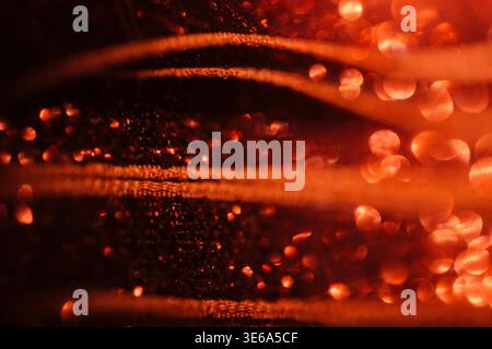 Nahaufnahme von rotem Stoff mit satten Texturen und einem weichen Bokeh-Effekt, der das Spiel von Licht und Schatten in den komplizierten Details unterstreicht Stockfoto