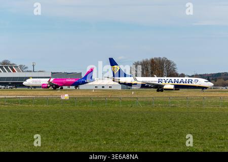 Memmingerberg, Bayern, Deutschland - 5. April 2026: Wettbewerb am Allgäuer Flughafen Memmingen: Flugzeuge der Billigfluggesellschaften Ryanair und Wizz Air auf dem Vorfeld. Beide Fluggesellschaften beherrschen den Markt für Billigflugzeuge in Süddeutschland *** Konkurrenz am Allgäu Airport Memmingen: Flugzeuge der Billigflieger Ryanair und Wizz Air auf dem Vorfeld. Beide Airlines dominieren den Markt für preiswerte Flugreisen in Süddeutschland Stockfoto