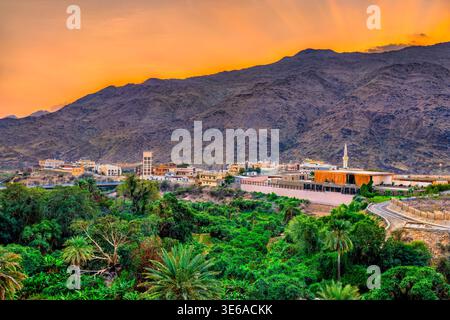 Ein wunderschöner Sonnenuntergang über den Bergen und üppigen Palmenhainen rund um das Dorf Ain in der Region Al Bahah in Saudi-Arabien. Stockfoto