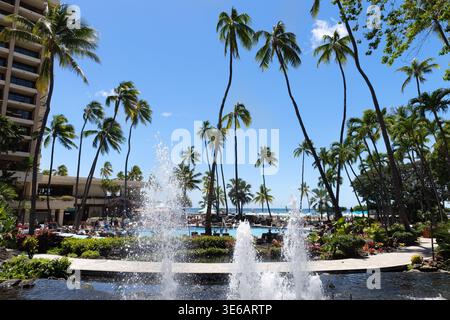 Hotelpool und tropischer Garten mit Palmen und Meerblick in Waikiki, Honolulu, Oahu, Hawaii, USA Stockfoto