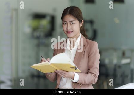 Schöne asiatische Geschäftsfrau, die sich ein lehrreiches Webinar auf Laptop ansieht. Finanzierungskonzept Stockfoto
