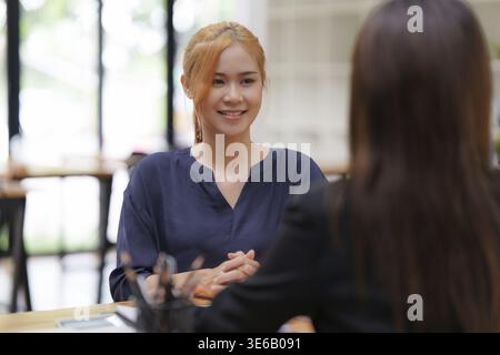 Geschäftsfrau erklärt, bevor sie einen Vertrag über den Kauf eines Hauses unterschreibt. Konzept des Bankmanagers Stockfoto