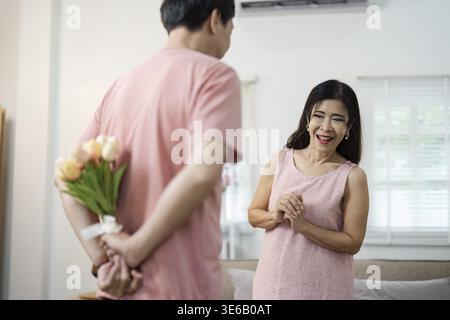 Ein Seniorenpaar teilt sich einen freudigen Moment am Valentinstag und tauscht ein Lächeln und romantische Gesten in gemütlicher Atmosphäre aus Stockfoto