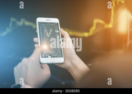 Geschäftsmann Trader Investor mit Handy-Anwendung mit Kryptowährung Aktienmarkt Graph. Aktienchart, Anlagekonzept Stockfoto