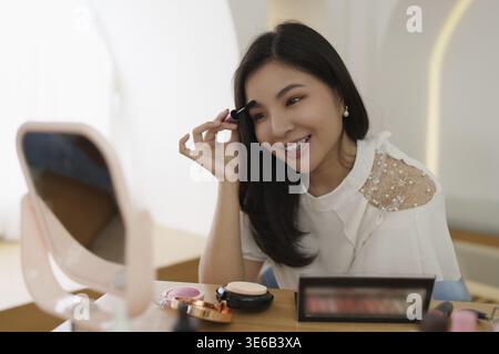 Frau mit Kosmetik und versuchen, sich nach ihrem Vlogger zu bilden Stockfoto