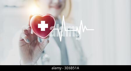Kardiologe mit rotem Herz in Privatklinik. Medizintechnik Diagnostik von Herz-Konzept Stockfoto