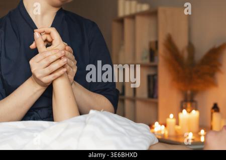 Massagetherapeut, der eine entspannende Handmassage und Behandlung für eine weibliche Kundin durchführt, die ein Spa-Wellness-Verfahren genießt Stockfoto
