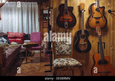Alte Jazz-Akustik-Gitarren an einer Holzwand, Details zum Lebensstil eines Gitarrenreparateurs. Stockfoto