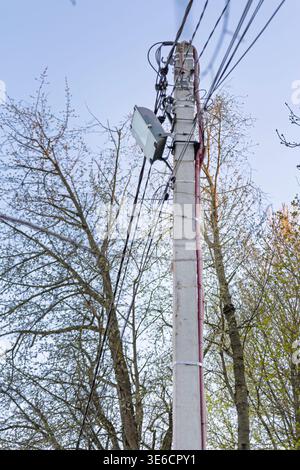 Versorgungsmast mit Straßenlaterne und Elektrodrähten gegen Blue Sky Stockfoto