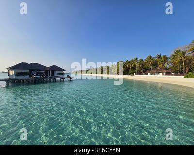 Dieses tropische Reiseziel bietet luxuriöse Villen und klares Wasser an einem Strand auf den Malediven für einen perfekten Urlaubsort. Stockfoto