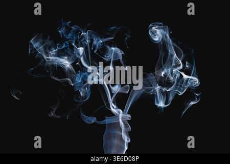 Abstrakter weiß-blauer Rauch bildet dynamische wirbelnde Muster auf schwarzem Hintergrund. Für Design, Hintergründe, Texturen und atmosphärische Effekte. Stockfoto